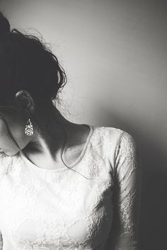 a black and white photo of a woman in a wedding dress with her hair pulled back