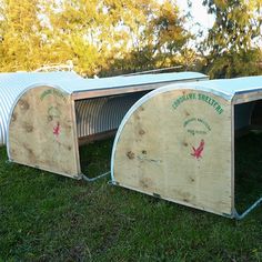 two large wooden shelters sitting in the grass