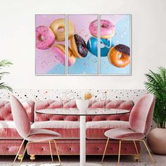 three paintings of doughnuts and donuts hanging on a wall in a living room