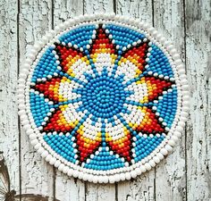 a colorful beaded wall hanging on the side of a white wooden door with a butterfly