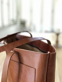 "Large leather bag, made with the highest quality veg tanned leather. Its clean design makes this beautiful bag a versatile every occasion bag. Features: - Highest quality Full Grain Veg Tanned leather - Aprox Size: 13-14 in wide (33-36 cm) - easily fits a 14\" laptop 13 in high (33 cm) 4.7 in deep (12 cm) - Outside pocket of 13,4\" x 9\" (34x23 cm) - 2 big inside pockets (big enough for your ipad) - Optional features: (available in the right section of this listing). *ADD ZIPPER: The zipper is Classic Brown Shoulder Bag With Pockets, Brown Softback Shoulder Bag For Everyday Use, Brown Softback Shoulder Bag With Pockets, Brown Softback Satchel For Everyday, Everyday Brown Softback Shoulder Bag, Brown Bucket Bag With Double Handle And Pockets, Brown Shoulder Bag With Pockets For Everyday, Brown Bucket Bag With Pockets, Brown Bags With Pockets For Everyday Use