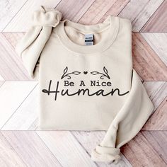 "Are you looking for a sweatshirt that will remind you to be kind? Look no further than our \"Be a Nice Human\" Sweatshirt! The soft, comfortable fabric and inspirational wording will make you feel good every time you wear it. It's also the perfect gift for anyone who loves being kind and wants to show off their personality.  Be Kind Sweatshirt, Nice Human Shirt, Inspirational Shirt, Be a Nice Human Shirt, For Her Gift, Be A Nice Human Sweatshirt, Be A Kind Human Tee, Positivity Hoodie, Be Nice Sweatshirt, Inspirational Hoodie, Nice Human Hoodie, Be Kind T Shirt, Motivational Shirt #bekind #beakindhuman #positivity #bekindshirt A sturdy and warm sweatshirt bound to keep you warm in the colder months. A pre-shrunk, classic fit sweater that's made with air-jet spun yarn for a soft feel and r Be Kind T Shirt, Positive Hoodie, Be Kind Shirt, Positive Shirt, To Be Kind, Kindness Shirts, Fun Sweatshirts, Inspirational Shirt, Be A Nice Human