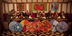 a group of people sitting at a table with decorated plates and candles in front of them