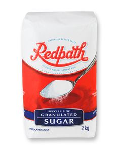 a bag of redpath granulated sugar next to a spoon on a white background