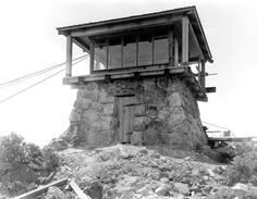 an old photo of a small tower on top of a hill with rocks and debris around it