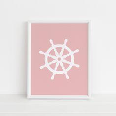 a pink and white poster with a ship wheel on it's side in front of a wall