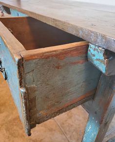 an old wooden table with a drawer open