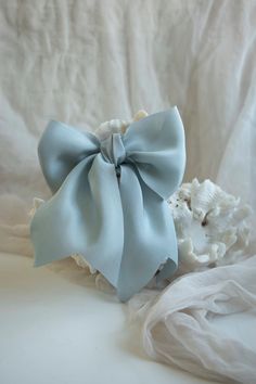 This beautifully rich and soft blue is created with a bit of alchemy and the color extracted from Peruvian Purple Corn! Like a calm waterfall, this classic blue silk ribbon is the perfect adornment for any bridal bouquet style. Shades may vary by batch. Our current batch has a hint of teal in the undertone. Sample Swatches are a 9-inch length sample of our 1.5-inch width ribbon. Elegant Blue Ribbon Bow, Elegant Blue Bow As Gift, Elegant Blue Bow For Wedding, Bridal Bouquet Styles, Blue Silk Ribbon, Purple Corn, The Undertones, Wooden Spools, Plant Dyes