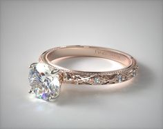 a diamond ring with filigrees on the band and an oval center stone