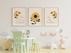 three sunflowers are hanging on the wall above a small table and chairs in a child's room