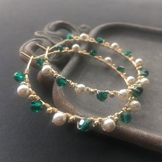 These beaded hoops are elegant and timeless! Handcrafted using emerald green Swarovski crystal and pearl elements. They are full of sparkle and luminous shine! Large yet dainty and lightweight, these earrings are perfect for elevating everyday looks.Emeralds are the birthstone for May, these hoops make a thoughtful gift for a special friend!Handcrafted using 20g, 14k gold filled wire. Each hoop is hammered and polished. The hoops are approximately 2" (measurement includes the beads).The Swarovsk Elegant Green Wire Wrapped Hoop Earrings, Green Hoop Earrings For Wedding, Green Wire Wrapped Hoop Earrings, Green Wire-wrapped Hoop Earrings, Elegant Green Beaded Hoop Earrings, Hoops With Pearls, Gemstone Chip Necklace, Wired Jewelry, Emerald Green Crystal