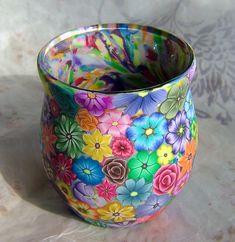 a colorful glass vase with flowers painted on it