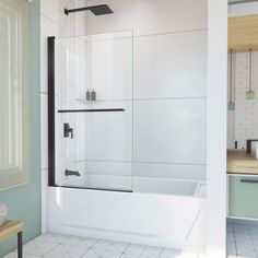 a bathroom with a white tiled floor and green walls, along with a glass shower door