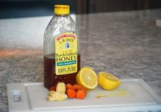 a bottle of honey sitting on top of a cutting board