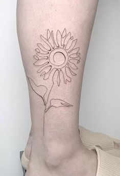 a woman's lower leg with a sunflower tattoo on the back of her thigh