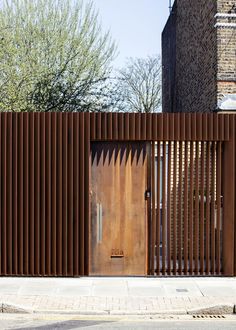 a large wooden door on the side of a brick building with metal slats covering it