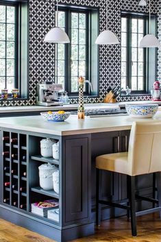 a large kitchen with an island and two chairs in front of the countertop area