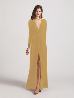 a woman wearing a long yellow dress with a slit in the front and an open v - neckline