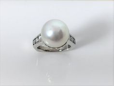 Beautiful almost perfectly round South Sea Cultured Pearl set in a 18k white gold ring with diamonds on the shank. Perfect for everyday wear but also that finishing touch on a special occasion outfit. Pearl measures 13.0 mm round Diamonds weigh approximately .66tw Ring size: 5 3/4 Pearl Diamond Ring, 2024 Moodboard, Occasion Outfit, Pearl And Diamond Ring, Jade Bangle, Special Occasion Outfits, Sea Pearl, Pearl Set, South Sea Pearls