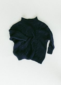 a blue sweater laying on top of a white surface