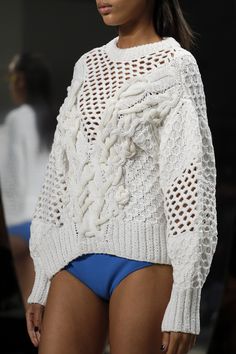 a model wears a white sweater and blue panties