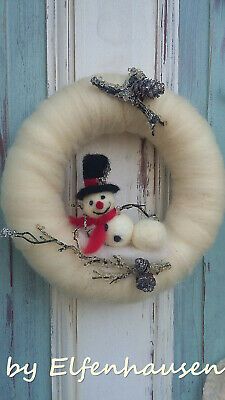 a white wreath with a snowman on it