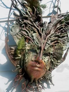 a woman's face is covered in vines and branches