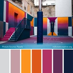 a basketball court with stairs and painted walls in shades of orange, pink, purple, blue