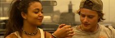 a young man and woman are eating food