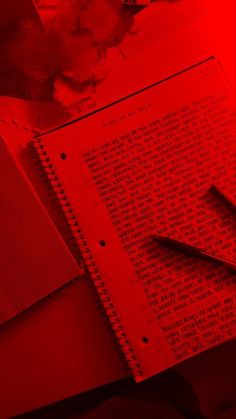 a pen and paper on top of a red table