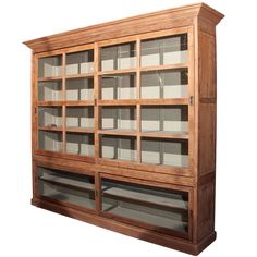 a wooden bookcase with glass doors on the front and bottom shelves, all made out of wood