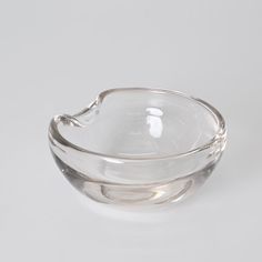 an empty glass bowl sitting on top of a white table