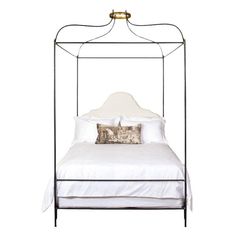 an iron canopy bed with white linens and pillows on the bottom, along with two throw pillows