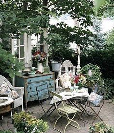 an outdoor patio with chairs, tables and potted plants