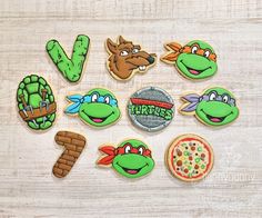 decorated cookies are arranged in the shape of teenage mutant turtles and pizzas, along with letter v