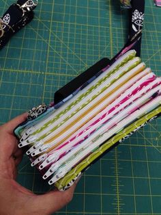 a person is holding a bunch of fabric in front of a cutting board with scissors