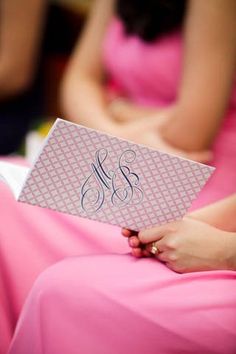 the bridesmaids in pink dresses are holding their monogrammed cards