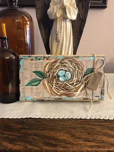 a wooden box with a bird's nest on it and two bottles next to it