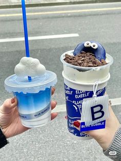 two people are holding up ice creams with googly eyes and one is blue