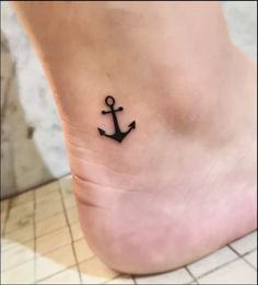 a small anchor tattoo on the ankle