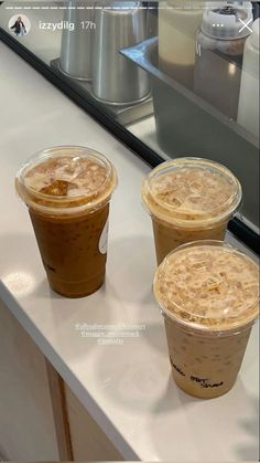 three iced coffees sitting on top of a counter