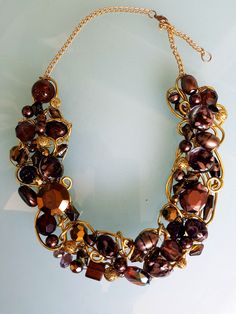 This necklace created using gold wire hand twisted to incorporate the different shades brown beads. Necklace shaped to fit the neckline, so is quite flexible. Necklace finished with the chain. Length can be adjusted. Necklace measures 26 inches with a lobster clasp. In my collection you can find this necklace in a variety of colors. I am constantly creating new pieces to add to my collection, so I invite you to follow my shop for exclusive new releases. Your purchase will come carefully packaged in an organza sachet. Gold Wire Wrapped Metal Beaded Necklaces, Gold Wire Wrapped Beaded Necklaces, Gold Wire Wrapped Metal Beaded Necklace, Gold Metal Wire Wrapped Beaded Necklace, Brown Costume Jewelry Beaded Necklaces For Party, Unique Gold Wire-wrapped Beaded Necklace, Unique Gold Wire Wrapped Beaded Necklace, Elegant Gold Necklace With Copper Wire, Elegant Brown Metal Beaded Necklace