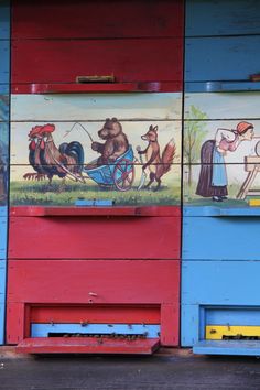 painted mural on the side of a building depicting animals and people in a wheelbarrow