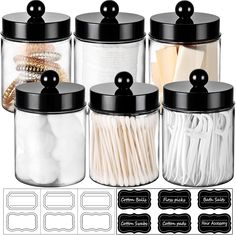 four glass jars with black lids and white cotton swabs