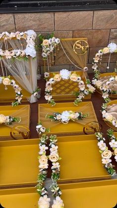 several yellow boxes with white flowers and ribbons on them, all lined up in rows