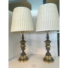 two lamps sitting on top of a white table next to each other, one is turned off