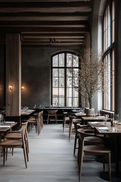 an empty restaurant with tables and chairs in front of large windows that look out onto the street