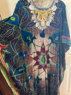 This is a gorgeous homemade kaftan with hand embroidery.  I believe the fabric is a heavy cotton.  Almost like Kente Kloth.  There are no labels or tags.  The kaftan measures 23" across from seam to seam.  I think it is an XL to a 2X.  The colors are so vibrant and the fabric is heavy and beautiful. Bohemian Long Sleeve Embroidered Poncho, Bohemian Multicolor Print V-neck Kaftan, Bohemian Multicolor Embroidered Kimono, Traditional Multicolor V-neck Tunic, Green Bohemian Kaftan For Festive Occasions, Bohemian Kaftan With Kimono Sleeves And Floral Embroidery, Traditional Green Floral Print Kaftan, Bohemian Green Kaftan With Kimono Sleeves, Green Tunic Kaftan For Festivals