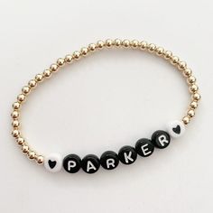 This listing is for one 14k gold filled 4mm beaded bracelet with black letters beads and the white hearts. Please leave name or initials in the notes section at checkout. This is the perfect stack bracelet. Gold filled means the bracelet will not tarnish or peel. Sizing: 5.5--kids 5.75-big kids 6-6.5-small adult wrist 6.75-sm/medium wrist 7-7.25-medium Classic Personalized Beaded Bracelets For Everyday, Personalized Black Beaded Name Bracelet, Everyday Black Name Bracelet With Letter Beads, Everyday Black Name Bracelet With Round Beads, Everyday Black Stretch Bracelet With Custom Name, Personalized Gold Bracelet, Gold Beaded Bracelets, Initial Bracelet Gold, Name Bracelets