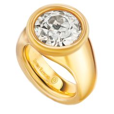 a gold ring with a large diamond in the center and an inscription on the side